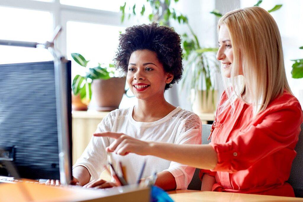 happy women with computer in office