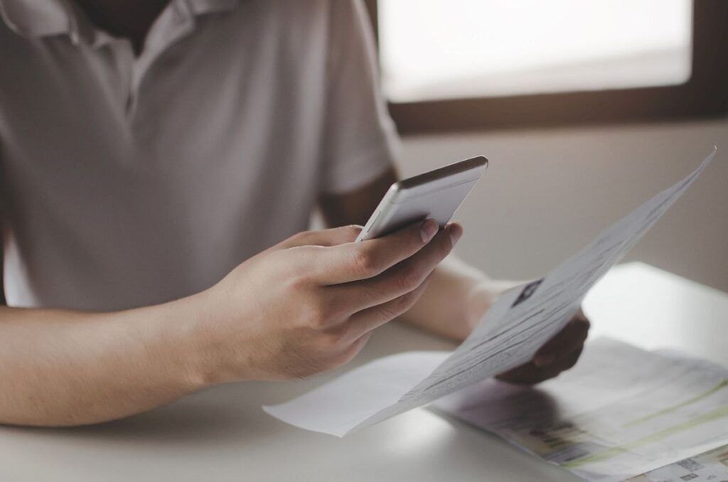 hands of young man using mobile smart phone for scan and payment online