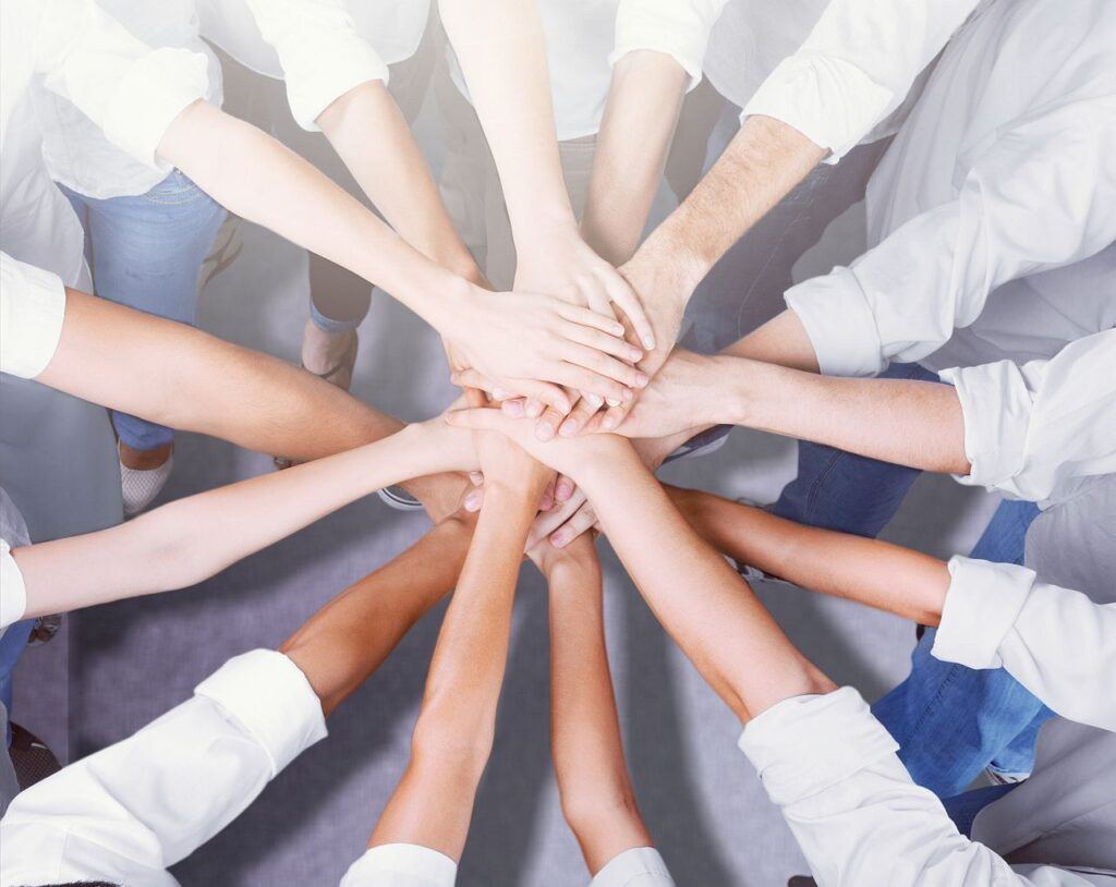 Group of people stacking hands together